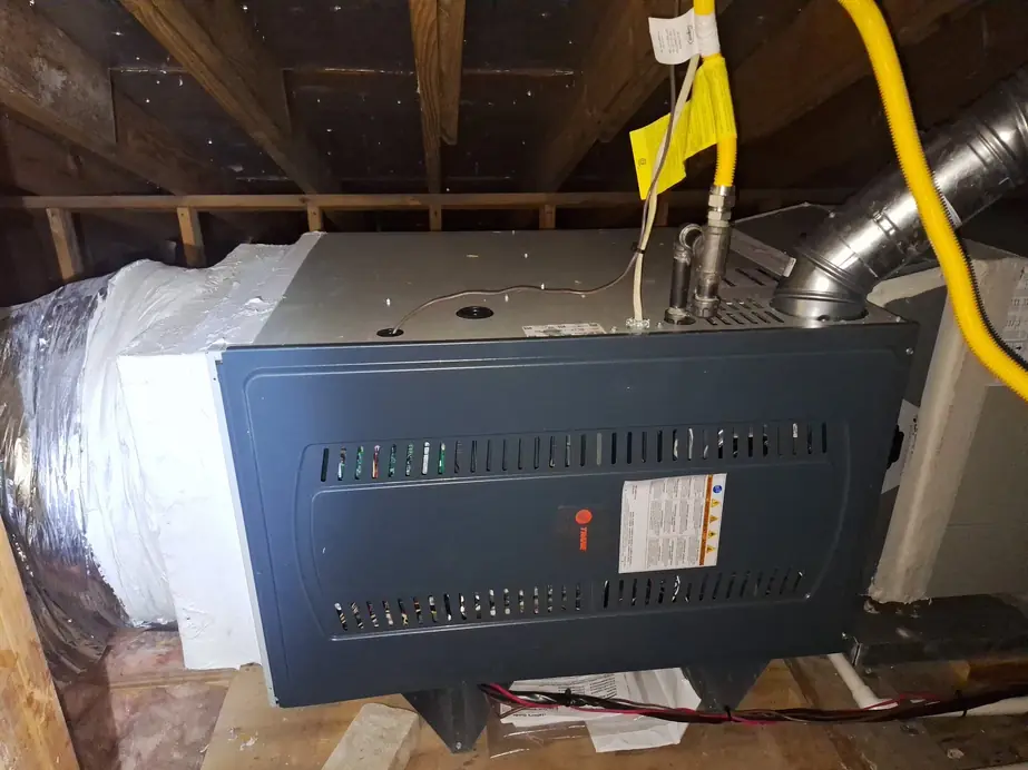 Trane gas furnace laid horizontally in an attic, new yellow gas flex at the valve