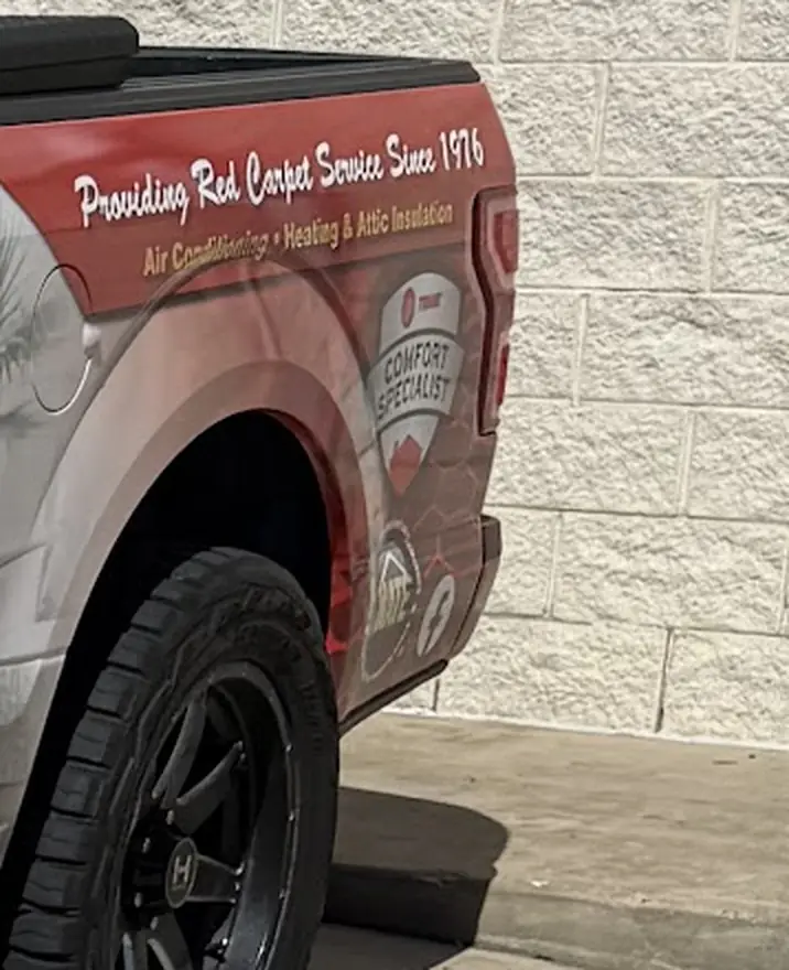 Rear quarter panel of the company F-150 reading Providing Red Carpet Service Since 1976, with a Trane Comfort Specialist badge